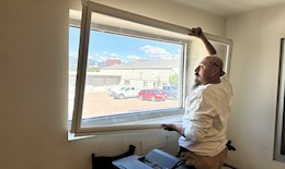 A technician installing an interior storm window